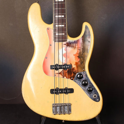 Egyedi Fender Jazz Bass gitár koptató naplemente árnyalataival, hagyományos pagodákkal és hegyvonulatokkal a háttérben