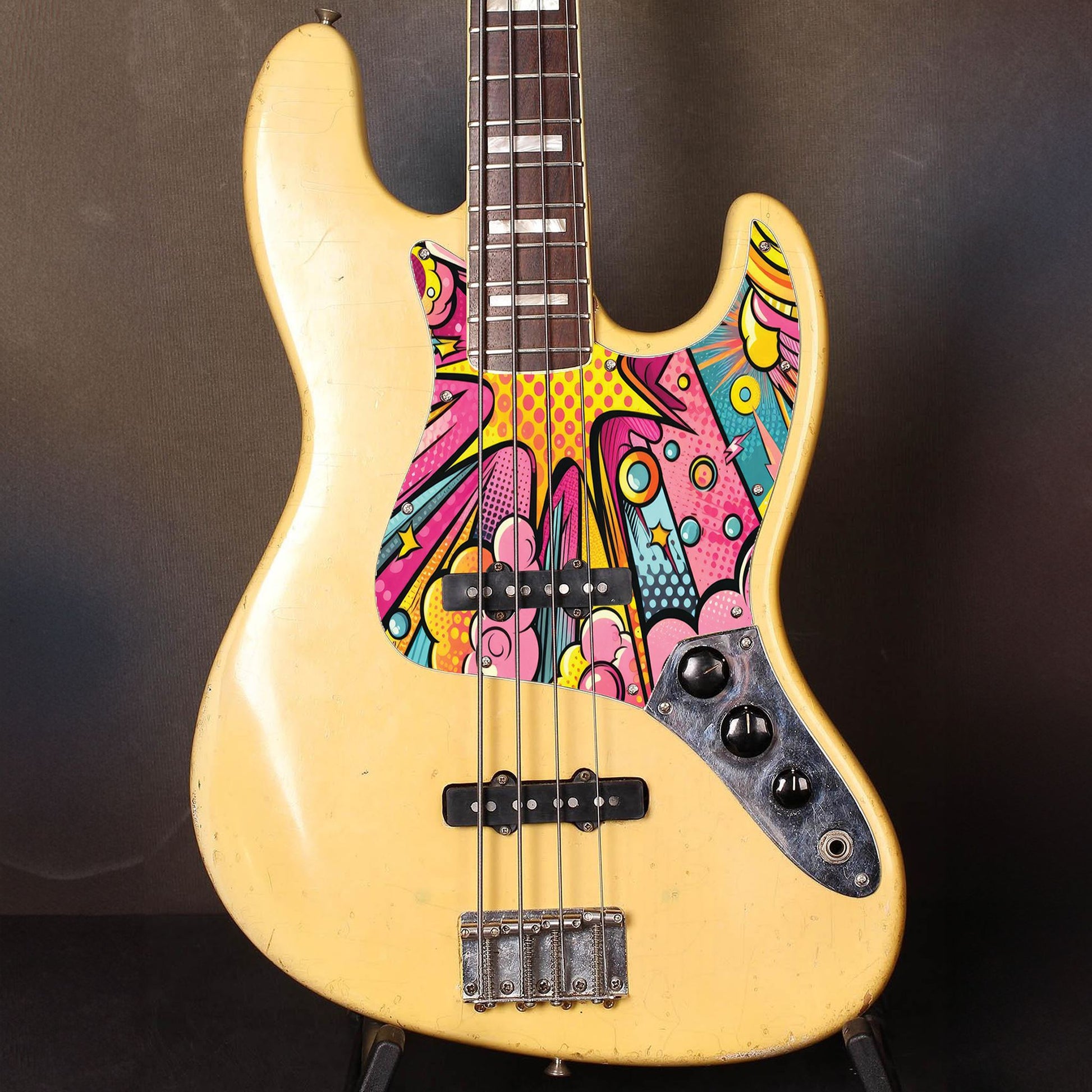 Egyedi Fender Jazz Bass gitár koptató vibráló pop-art mintázattal, sárga, rózsaszín és türkiz árnyalatokkal és energikus megjelenéssel