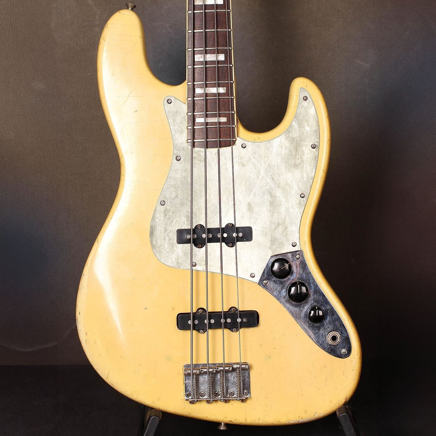 Egyedi Fender Jazz Bass gitár koptató törtfehér felülettel, finoman karcolt mintázattal és vintage hatású megjelenéssel