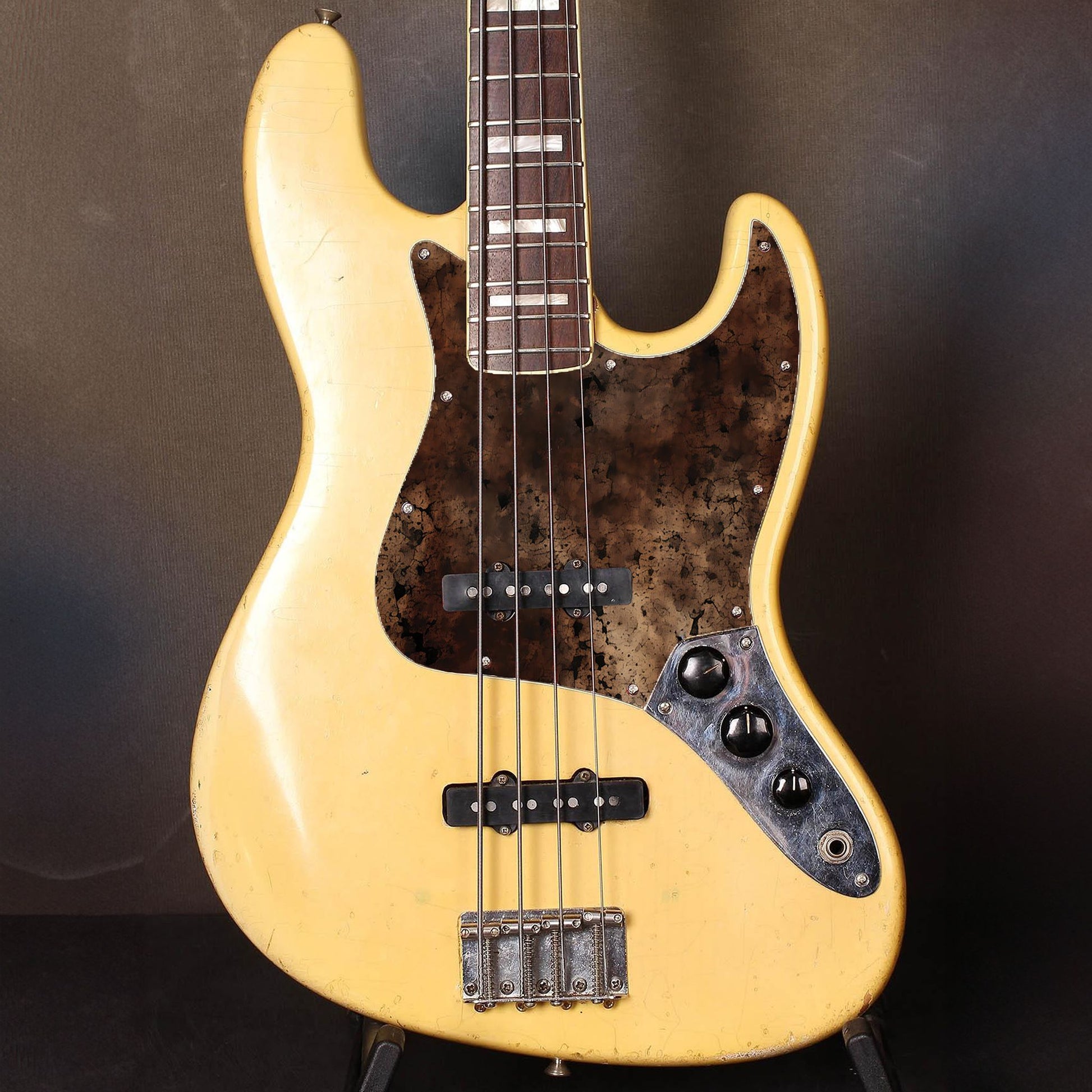 Egyedi Fender Jazz Bass gitár koptató sötét, repedezett textúrával, barnás-vöröses tónusokkal és égett hatású mintázattal