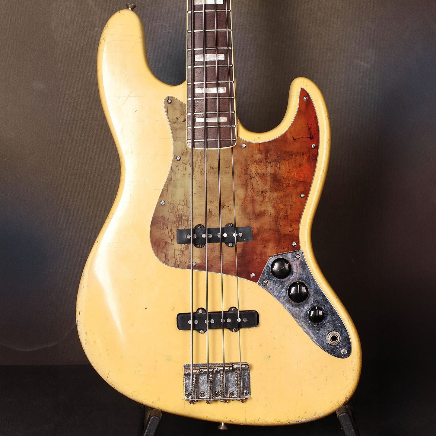 Egyedi Fender Jazz Bass gitár koptató repedezett, rozsdaárnyalatú textúrával, mélyvörös és barnás tónusokkal