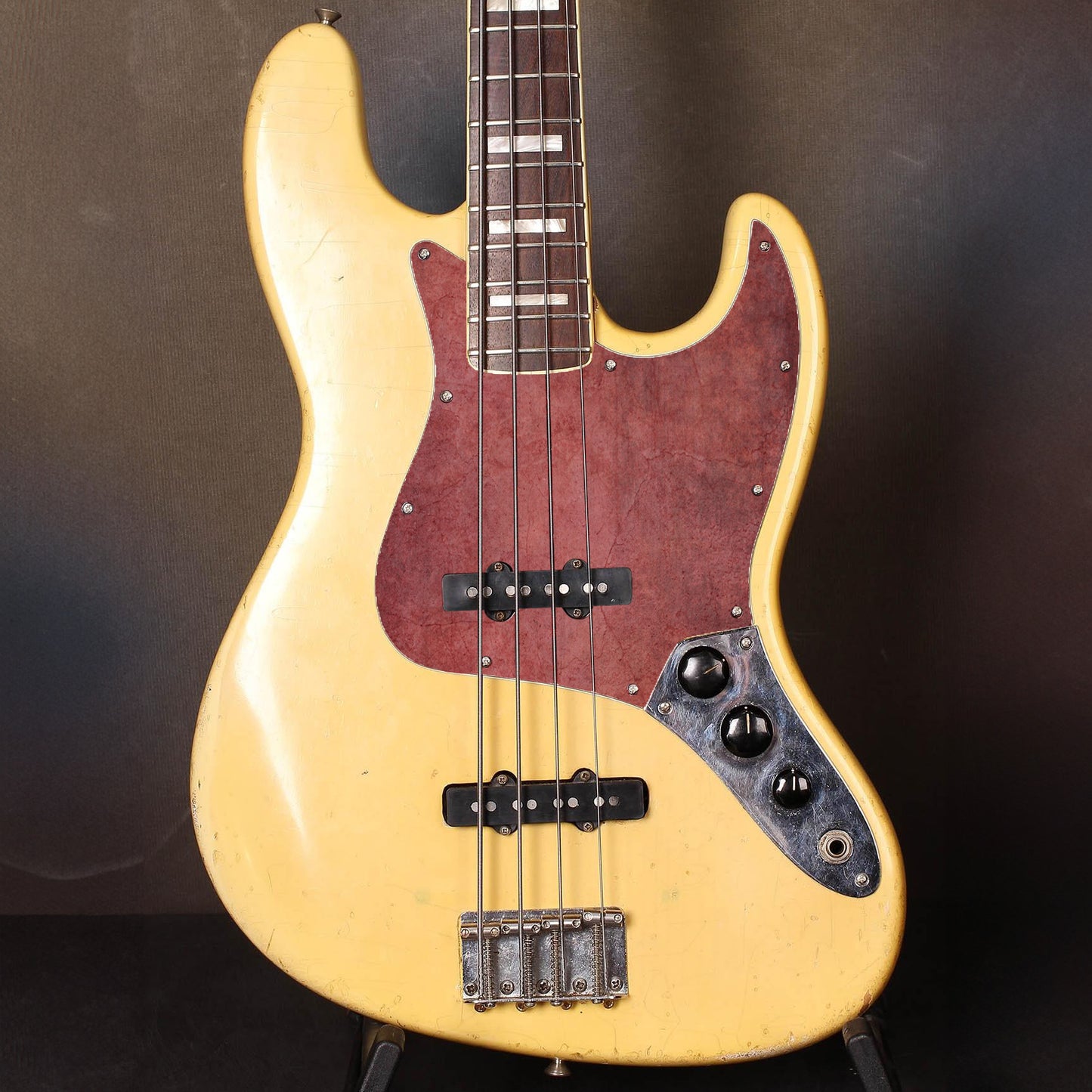 Különleges Jazz Bass koptató sötétvörös, kopott felülettel, amely időtálló és markáns dizájnt ad a hangszernek