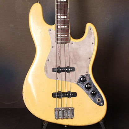 Egyedi Jazz Bass gitár koptató kopott, homokszínű árnyalattal, amely természetes és egyedi megjelenést kölcsönöz