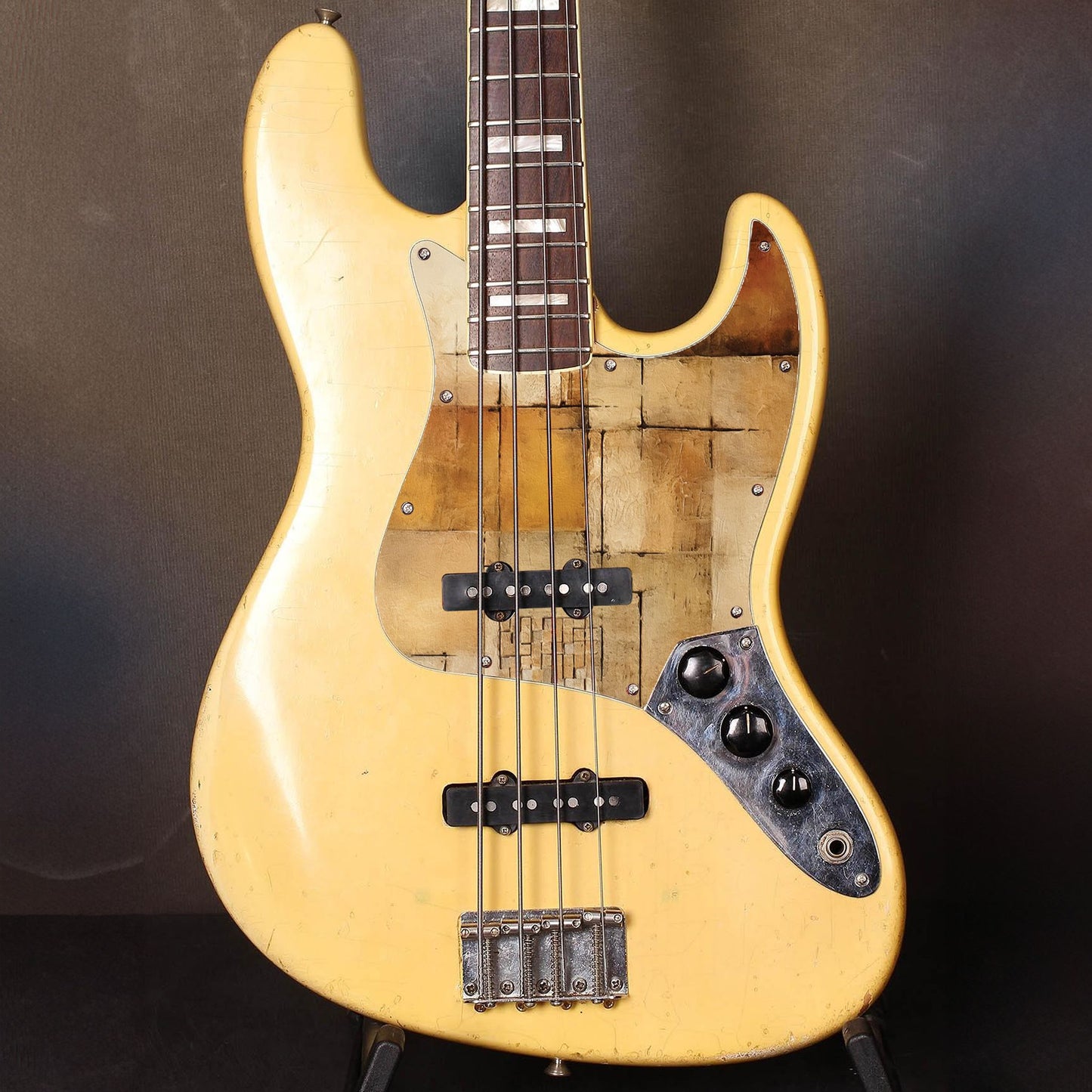 Egyedi Fender Jazz Bass gitár koptató meleg bézs és arany tónusokkal, geometrikus mintákkal és texturált felülettel