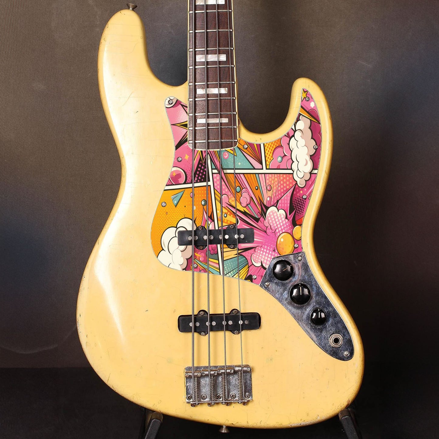 Egyedi Fender Jazz Bass gitár koptató lendületes pop-art mintázattal, erőteljes rózsaszín, sárga és kék árnyalatokkal
