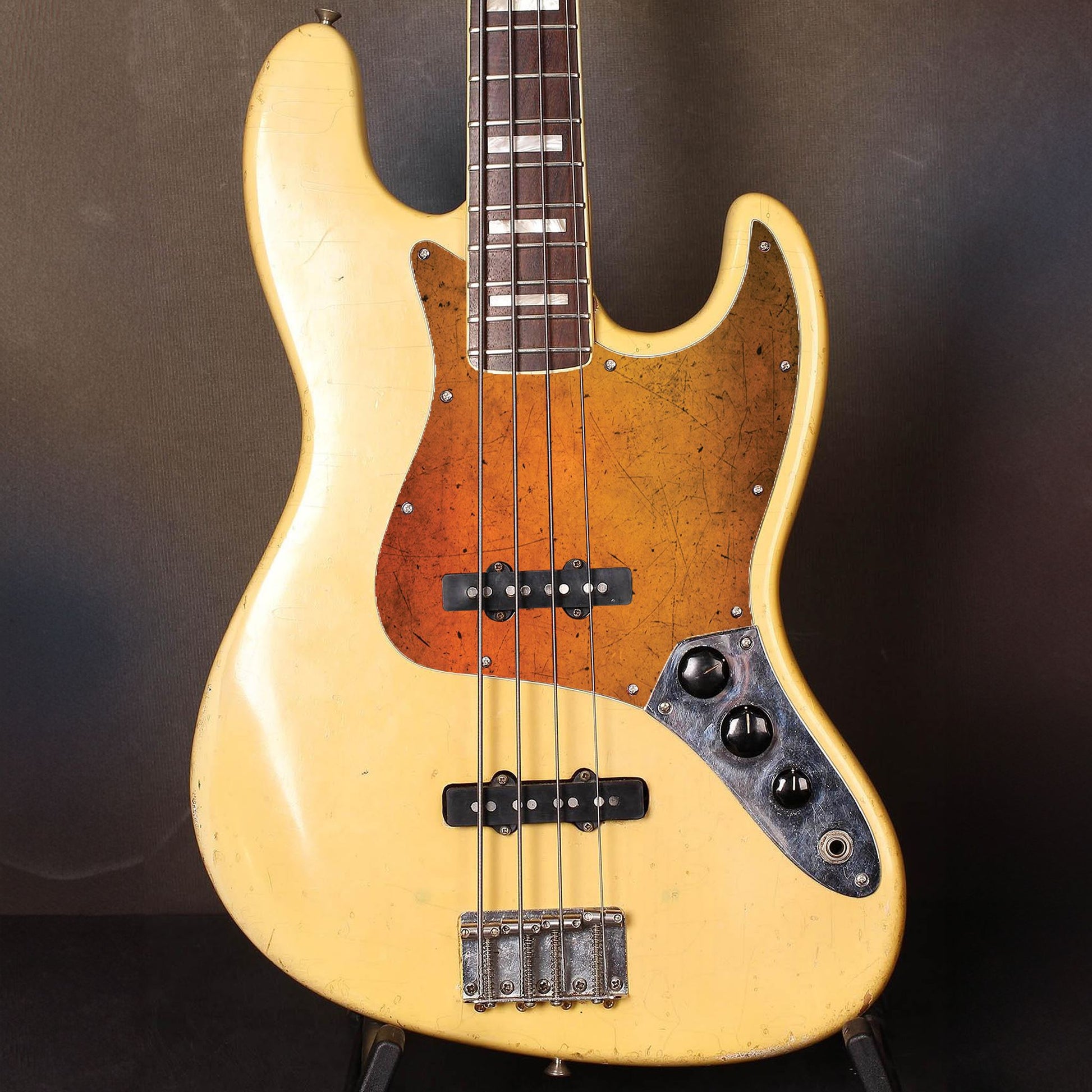 Egyedi Fender Jazz Bass gitár koptató élénk narancssárga tónusokkal, karcos felületi mintázattal és retró hatású megjelenéssel