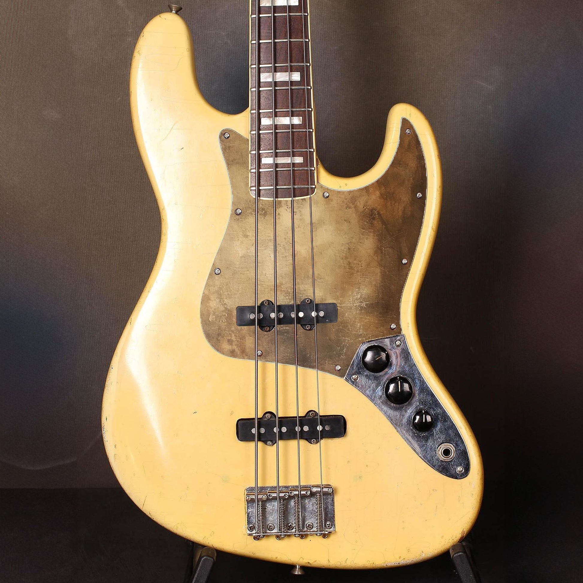 Különleges Fender Jazz Bass gitár koptató kopott, fényes arany felülettel, amely luxus és rusztikus hatást kelt egyszerre