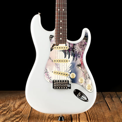 Egyedi Fender Stratocaster gitár koptató cseresznyevirágzó fákkal, hagyományos pagodákkal és hófödte hegycsúccsal a háttérben