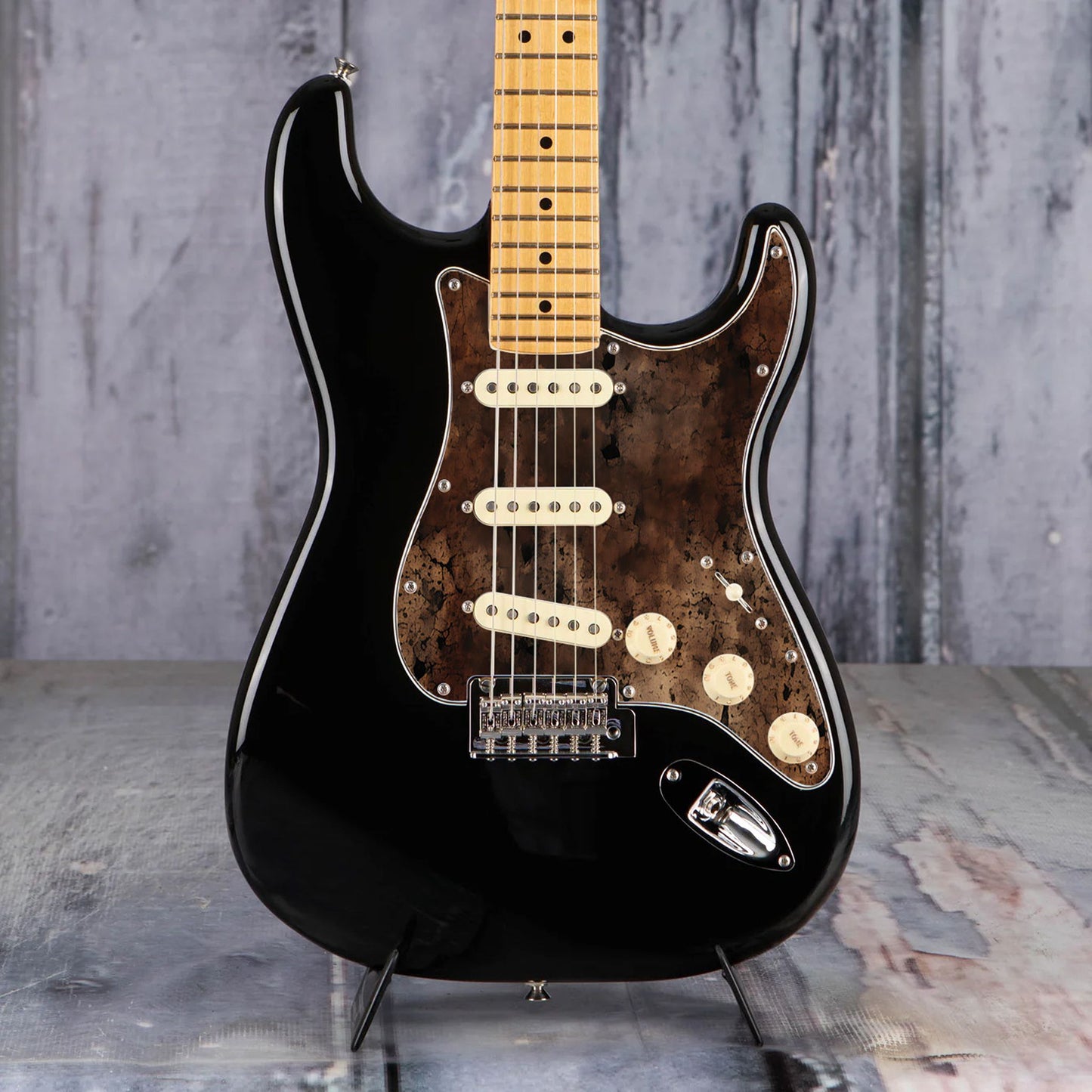 Egyedi Fender Stratocaster gitárkoptató sötét, repedezett textúrával, barnás-vöröses tónusokkal és égett hatású mintázattal