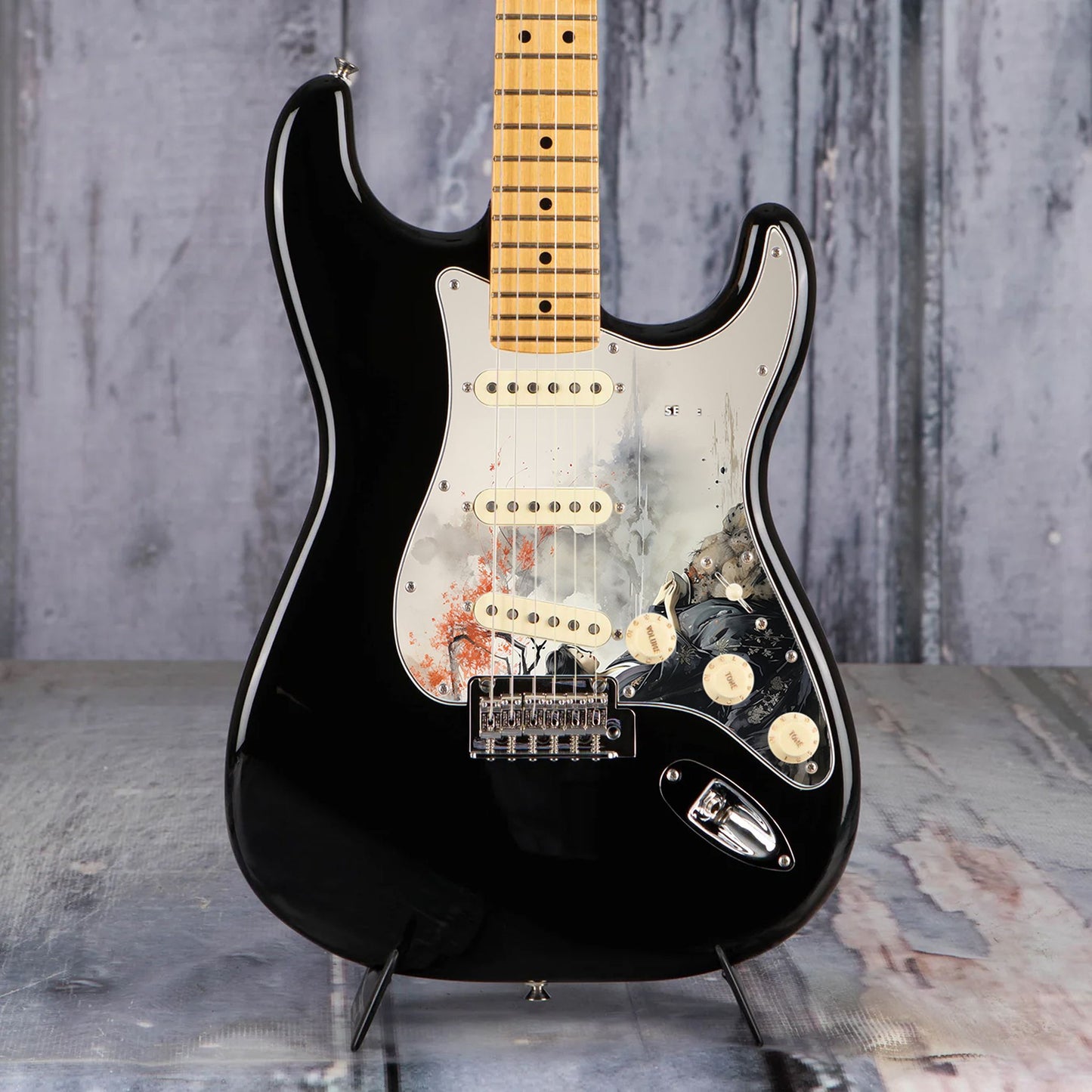 Egyedi Fender Stratocaster gitár koptató japán nőalak ábrázolásával, fekete kimonóban, vörös levelű fa alatt ülve a folyóparton