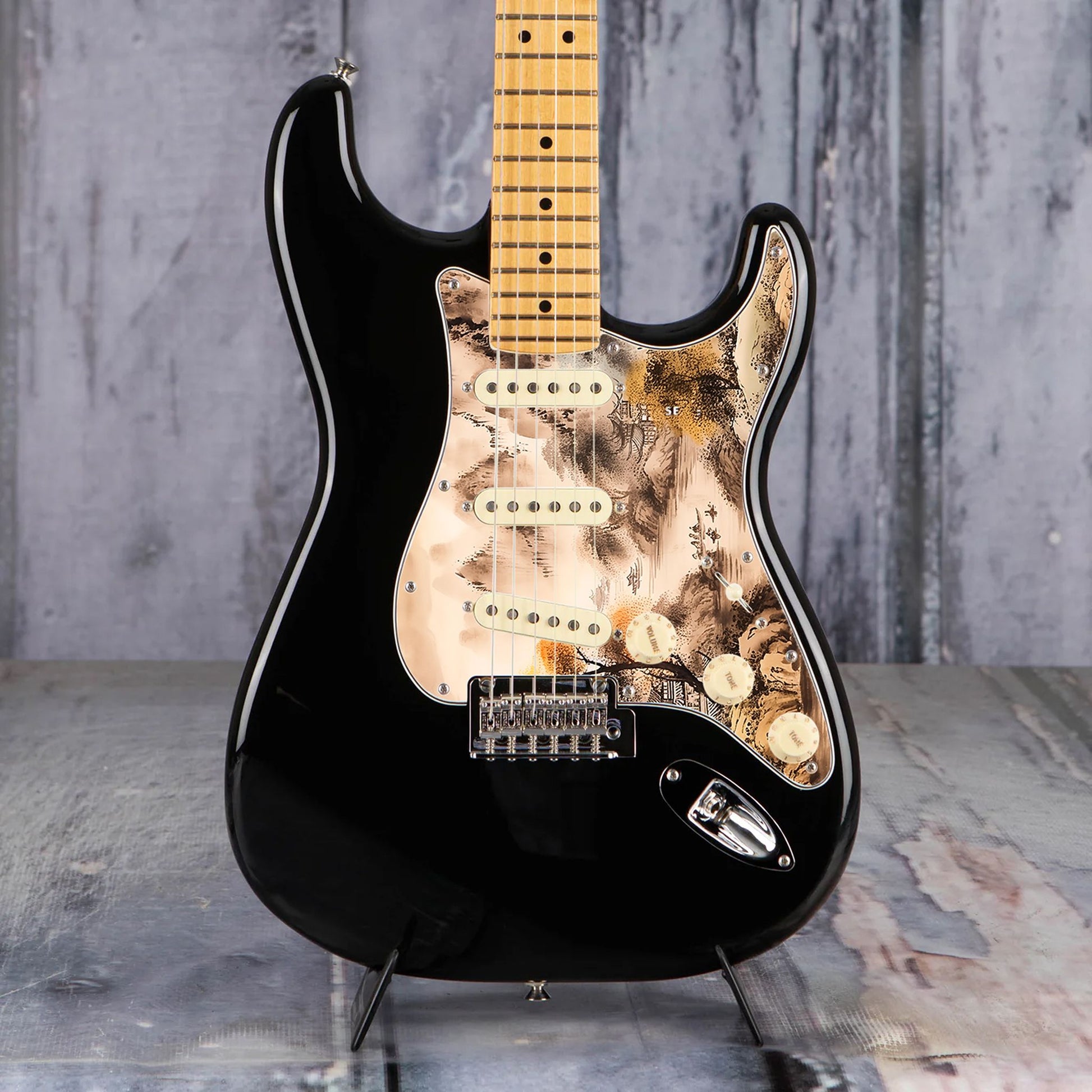 Egyedi Fender Stratocaster gitár koptató tradicionális tájképpel, narancssárga lombú fával, hegyekkel és folyón evező csónakokkal