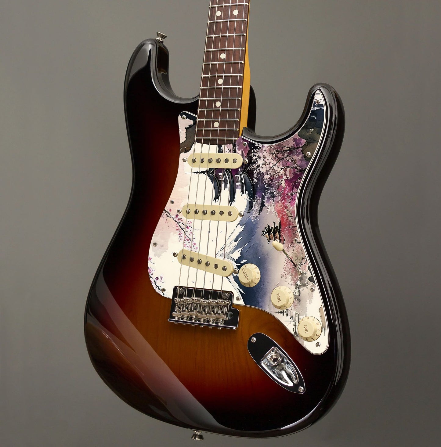 Egyedi Fender Stratocaster gitár koptató cseresznyevirágzó fákkal, hagyományos pagodákkal és hófödte hegycsúccsal a háttérben