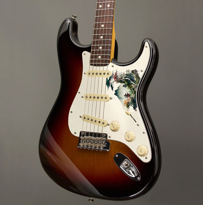 Egyedi Fender Stratocaster gitár koptató hegyekkel, tóparti pagodával és színes lombú fákkal a nyugodt tájban