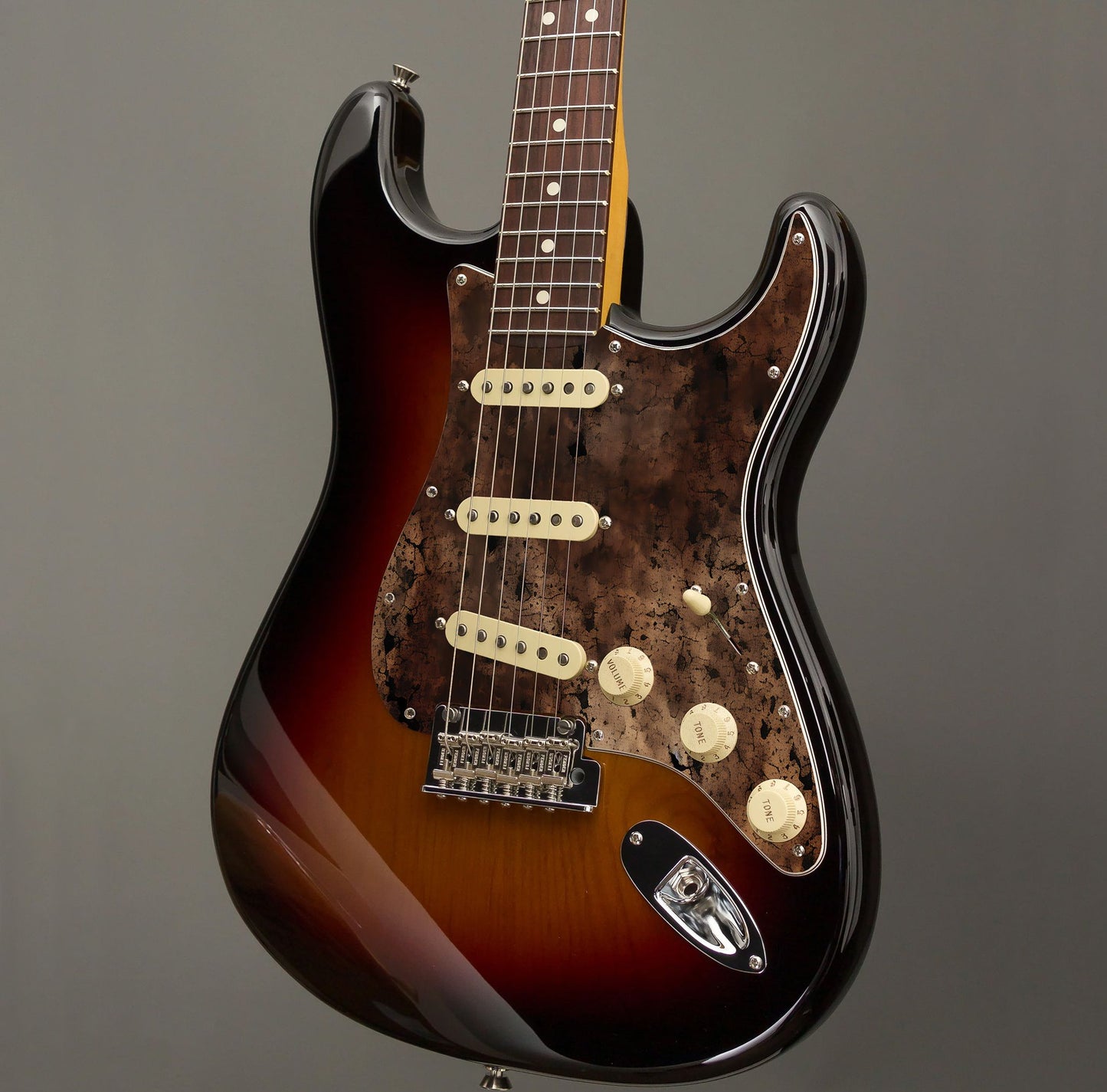 Egyedi Fender Stratocaster gitár koptató sötét, repedezett textúrával, barnás-vöröses tónusokkal és égett hatású mintázattal