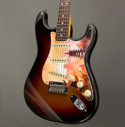 Egyedi Fender Stratocaster gitár koptató naplemente árnyalataival, hagyományos pagodákkal és hegyvonulatokkal a háttérben