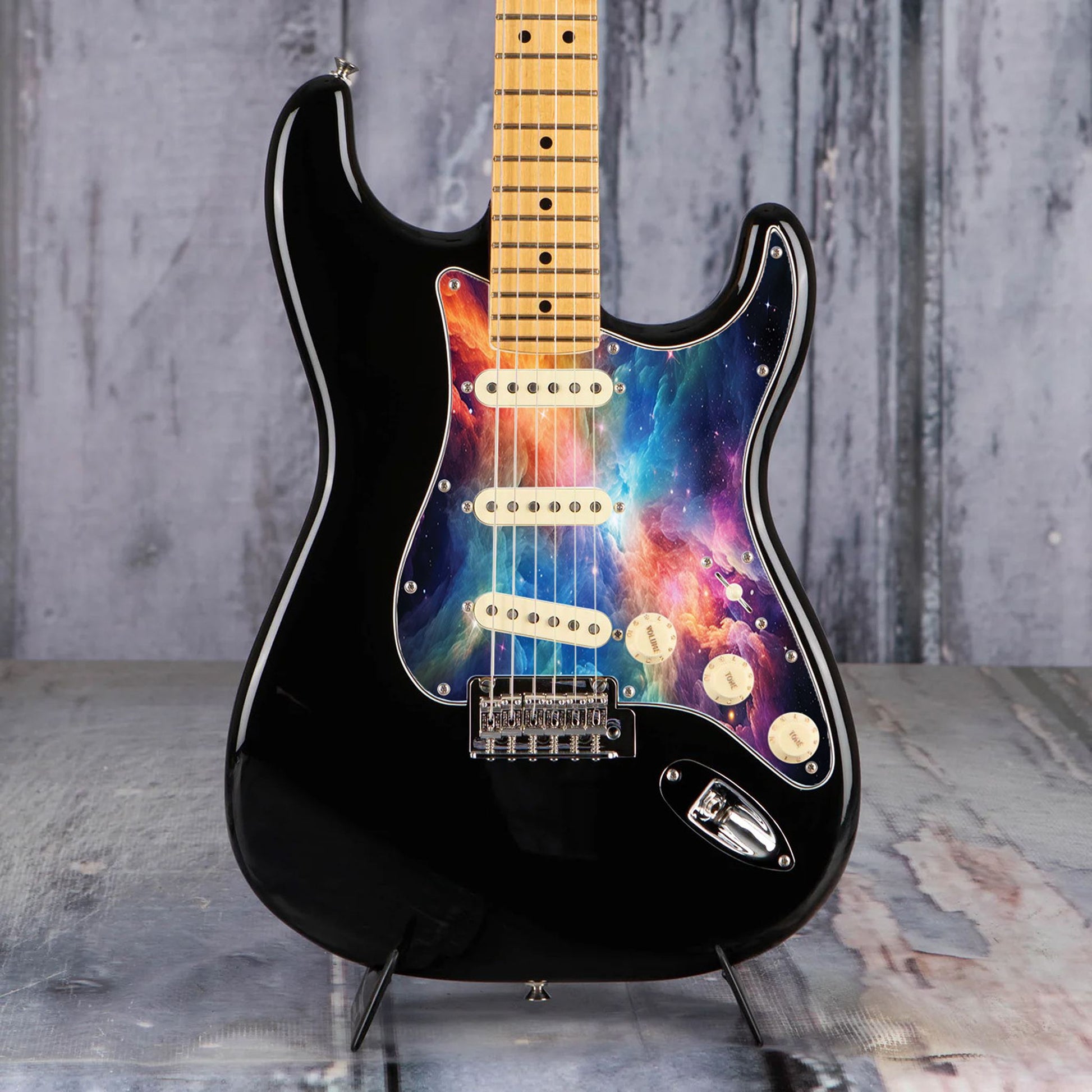 Egyedi Fender Stratocaster gitárkoptató színes galaxis mintázattal, élénk narancs, kék és lila ködfelhőkkel és ragyogó csillagokkal