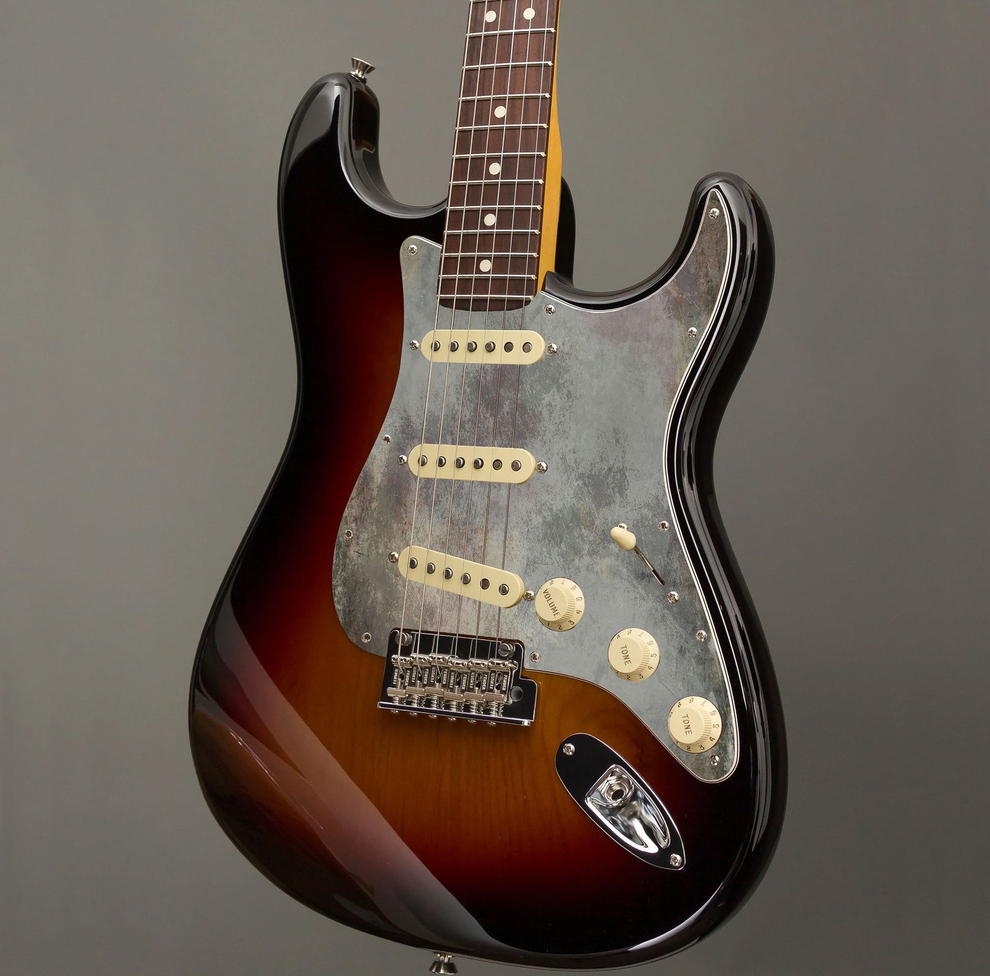 Egyedi Fender Stratocaster gitár koptató antikolt szürke tónusokkal, barnás-zöldes foltokkal és rusztikus textúrával