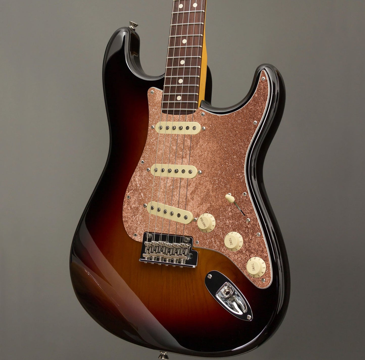 Egyedi Fender Stratocaster gitár koptató csillogó réz tónusokkal, finoman szemcsés felülettel és meleg színvilággal