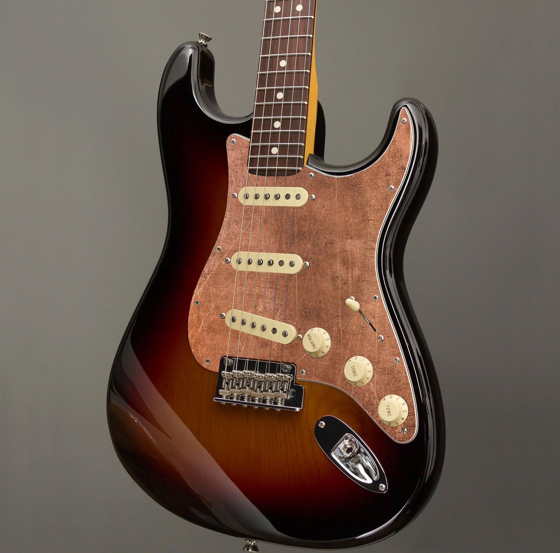 Egyedi Fender Stratocaster gitár koptató meleg réz tónusokkal, vintage hatású karcolásokkal és matt textúrával