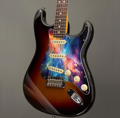 Egyedi Fender Stratocaster gitárkoptató színes galaxis mintázattal, élénk narancs, kék és lila ködfelhőkkel és ragyogó csillagokkal