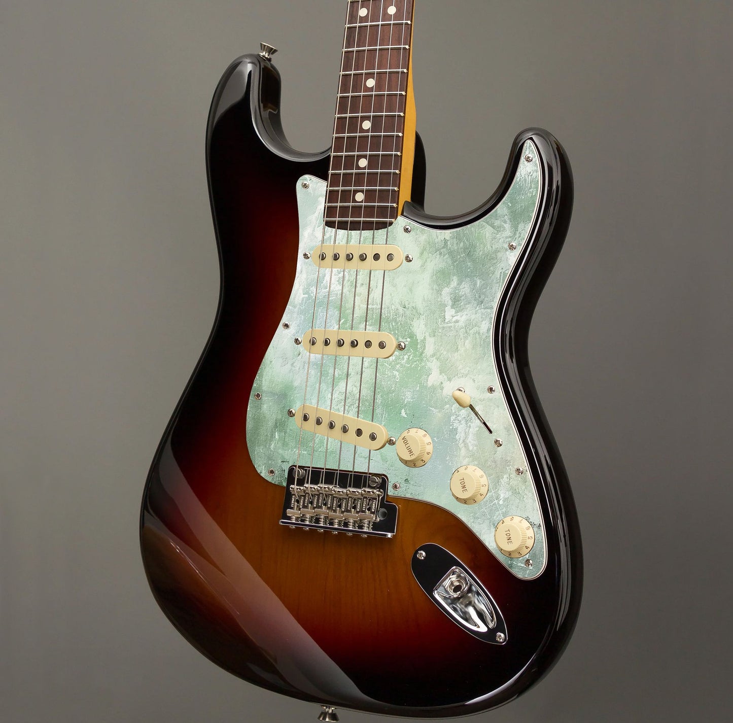 Egyedi Stratocaster gitár koptató zöldes-fehér árnyalatokkal, kopottas, festői dizájnnal díszítve