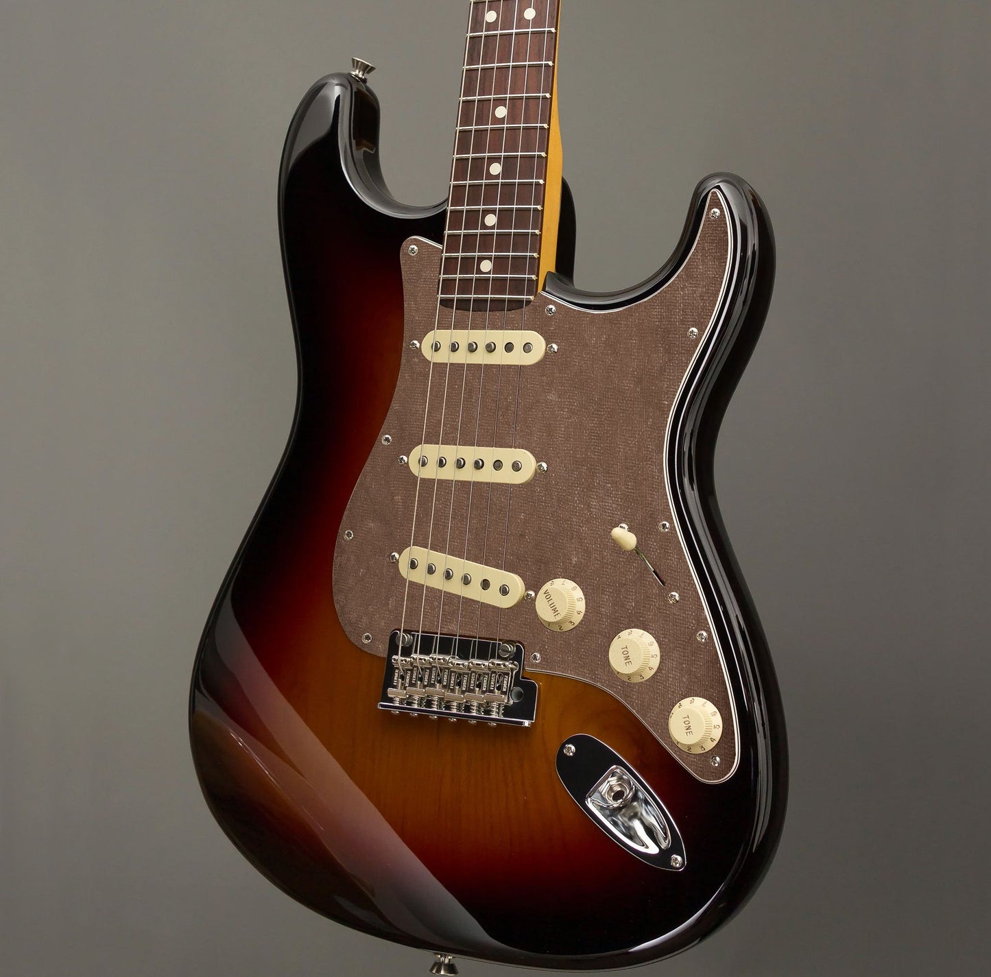 Egyedi Fender Stratocaster gitár koptató sötétszürke vászonhatású textúrával, finom rácsmintázattal és letisztult vintage megjelenéssel