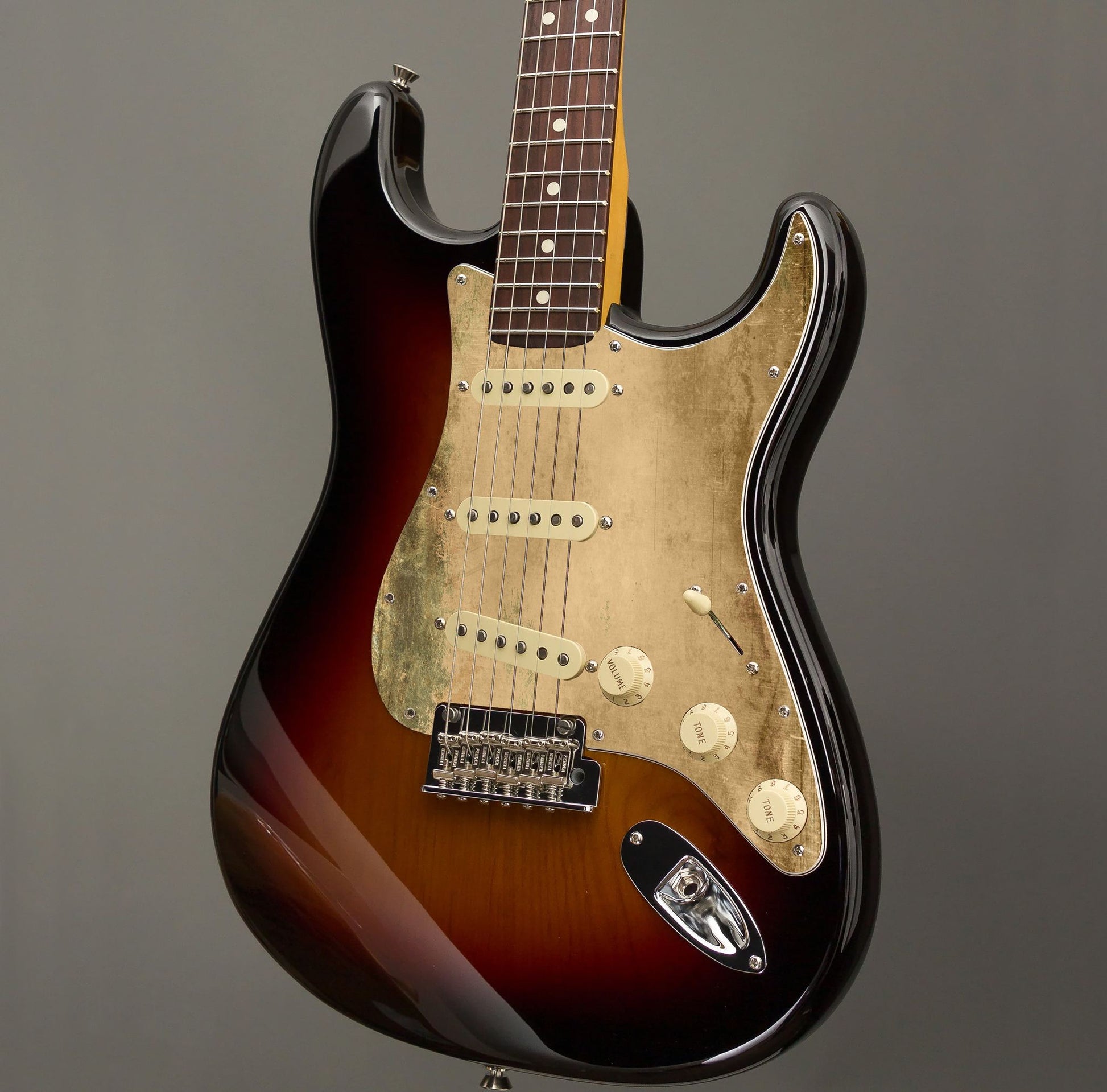 Egyedi Fender Stratocaster gitár koptató kopott arany tónusokkal, zöldes oxidációs mintázattal és matt textúrával