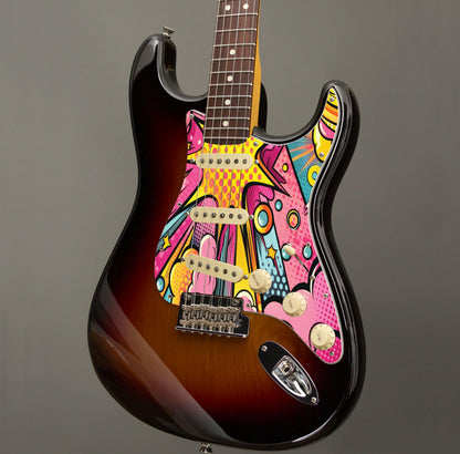 Egyedi Fender Stratocaster gitár koptató képregény stílusú robbanásszerű grafikával, élénk színekkel és modern vonalvezetéssel