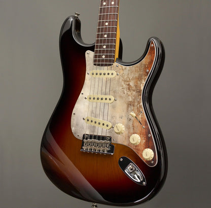 Egyedi Fender Stratocaster gitárkoptató rozsdásodó fémhatással, fakó bézs tónusokkal és mély narancsos oxidált foltokkal